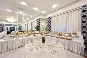 索倫托的住宿－歐陸酒店，一间设有白色桌子和餐具的大型用餐室