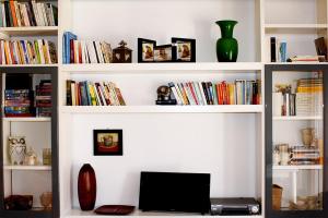 a book shelf filled with books and a laptop computer at Appartamenti Mori in Belluno
