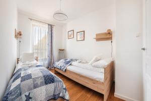 a bedroom with two beds and a window at Apartamenty Sun & Snow Gdańsk Bursztynowa in Gdańsk