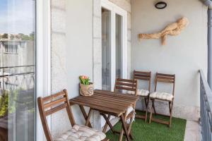 eine Veranda mit einem Holztisch und Stühlen auf dem Balkon in der Unterkunft Boutique Rentals - Boho Chic Apartment in Porto