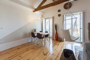 ein Wohnzimmer mit einem Esstisch und Stühlen in der Unterkunft Boutique Rentals - Boho Chic Apartment in Porto