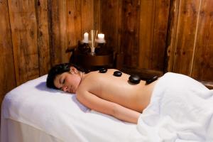 a shirtless woman laying on a bed in a bath room at Hotel Vienna in San Martino di Castrozza +37 photos