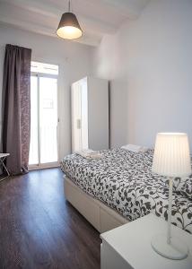 ロスピタレート・デ・リョブレガートにあるCamp Nou Apartmentのベッドルーム1室(ベッド1台、ランプ付きテーブル付)