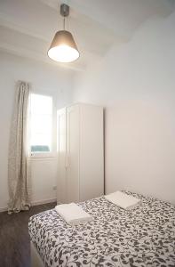 a bedroom with a bed with a black and white blanket at Camp Nou Apartment in Hospitalet de Llobregat