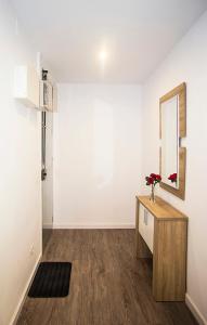 a white room with a table and a mirror at Camp Nou Apartment in Hospitalet de Llobregat