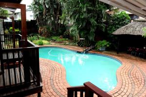 een groot blauw zwembad in een tuin bij Oliveroom Self Catering and B&B in Durban