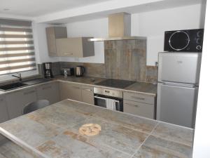 a kitchen with a large counter top with a refrigerator at Appartement Abadie in Bagnères-de-Bigorre