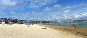 people on a beach near the ocean at Hotel Mon Ami-The Jubilee Hotel in Weymouth