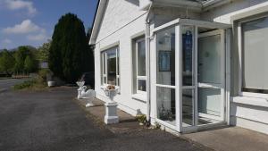 un edificio bianco con porte in vetro sul lato di Divine Mercy B&B a Knock