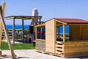 ein Holzspielhaus auf einer Terrasse mit Spielplatz in der Unterkunft Chainteris Villas, a Summer Dream, By ThinkVilla in Prínos
