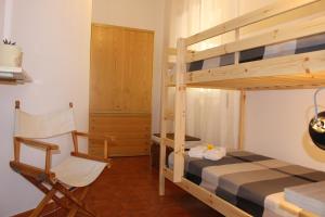 een slaapkamer met een stapelbed en een stoel bij A Dimora di Nenè in Marina di Modica