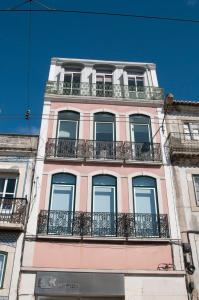 wysoki różowy budynek z oknami i balkonami w obiekcie Lisboa - Belem1886 River View #2Brd #2bath w Lizbonie