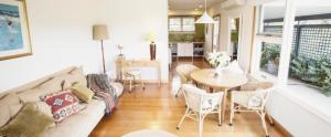 a living room with a couch and a table and chairs at Beeches By The Sea in Apollo Bay