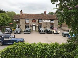 um grupo de carros estacionados em frente a um edifício em The Anchor Inn em Thornbury