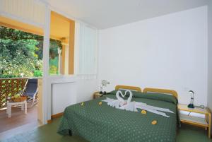 a bedroom with a green bed with white decorations on it at Hotel Marina 2 in Marina di Campo