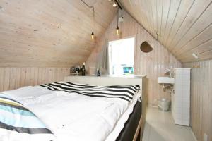 sypialnia z dużym białym łóżkiem w pokoju z drewnianymi ścianami w obiekcie Dancamps Nordsø Water Park w mieście Hvide Sande