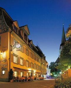 a building with a clock on the side of a street at Hotel Garni Krone in Radolfzell am Bodensee