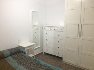 Apartamento Abadia Teruel في تيرويل: غرفة نوم بسرير وخزانة ومرآة