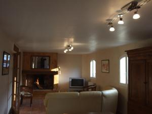a living room with a couch and a tv at La Ferme de Gayri, chalet d'exception avec sauna et jacuzzi à 5 minutes de St-Lary Soulan in Vielle-Aure