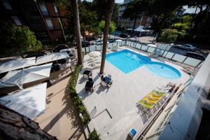 a swimming pool with a pool table and chairs at Hotel San Marco in Milano Marittima