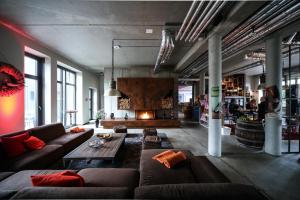 uma sala de estar com um sofá e uma lareira em Altes Stahlwerk Business & Lifestyle Hotel em Neumünster