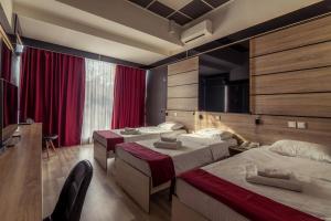 a hotel room with two beds and a tv at Hotel De KOKA in Skopje