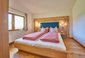 1 dormitorio con 1 cama grande con almohadas rojas y blancas en M's Wood Appartement, en Maishofen