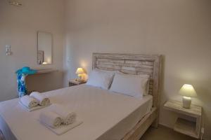 a bedroom with a large bed with towels on it at Lygaria Studios in Agia Pelagia