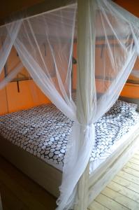 uma cama com uma rede mosquiteira em cima em Jachthaven Nieuwboer em Bunschoten