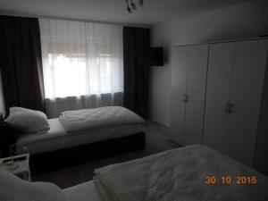 a bedroom with two twin beds and a window at Pension Harleshausen in Kassel