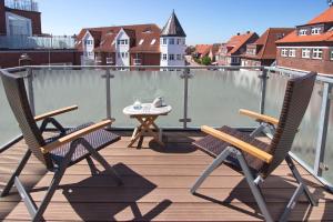 2 stoelen en een tafel op een balkon bij Hotel Westfalenhof in Juist