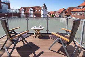 2 Stühle und ein Tisch auf dem Balkon in der Unterkunft Hotel Westfalenhof in Juist