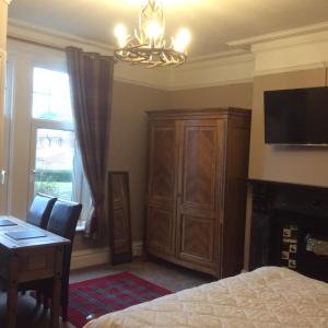 a bedroom with a bed and a desk and a television at Anchorage House in Whitby