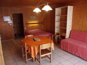 a small room with a table and a couch at Le Champbourguet in Super Besse
