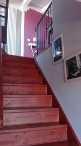 una escalera en una casa con escaleras de madera y barandilla en Dimora San Sebastiano, en Neive