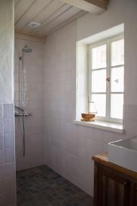 a bathroom with a shower and a sink and a window at Hansi Puhkemaja in Kuivastu
