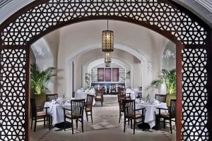 a dining room with tables and chairs and a chandelier at Steigenberger Alcazar in Sharm El Sheikh