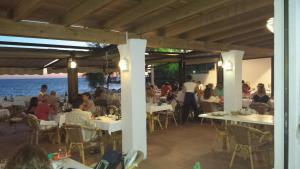 a group of people sitting at tables in a restaurant at Hostal Restaurante Playa in Colònia de Sant Jordi