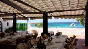 a restaurant with tables and a view of the ocean at Hostal Restaurante Playa in Colònia de Sant Jordi