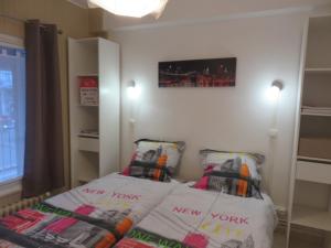 een kleine kamer met een bed en twee kussens bij Gîte du Vieux Marché in Le Havre