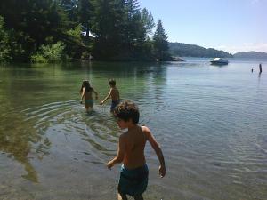 Tre bambini che giocano in acqua su un lago di Casa de Montaña Excelente Vista Pre-Viaje 2022 a San Carlos de Bariloche