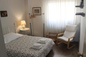 a bedroom with a bed and a chair and a window at Tudela y Bardenas a tus pies in Tudela