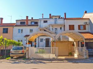 dom z bramą i samochodem zaparkowanym przed nią w obiekcie Apartments Tereza 1352 w Puli