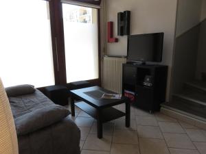 a living room with a couch and a tv at Gîte du Vieux Marché in Le Havre