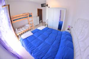 a bedroom with a bed with a blue comforter at Villa delle Muse da Imma in Palinuro
