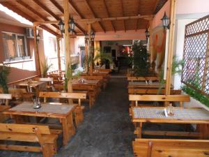 オブゾルにあるGuest House Liliaの木製のテーブルとベンチが備わる空きレストランです。