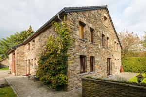 een bakstenen gebouw met klimop aan de zijkant bij A la ferme du Pere Eugene in Malmedy