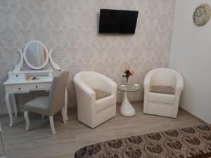 a room with two chairs and a desk and a mirror at Apartments Jo in Senj