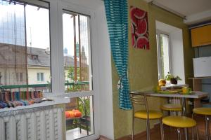 a kitchen with a window and a counter with stools at Catedra View Apartment in Ternopil +17 photos