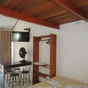 a bedroom with a bed and a table and chairs at Recanto da Ilha in Abraão
